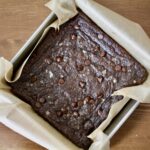 chocolate brownies in a parchment lined baking square