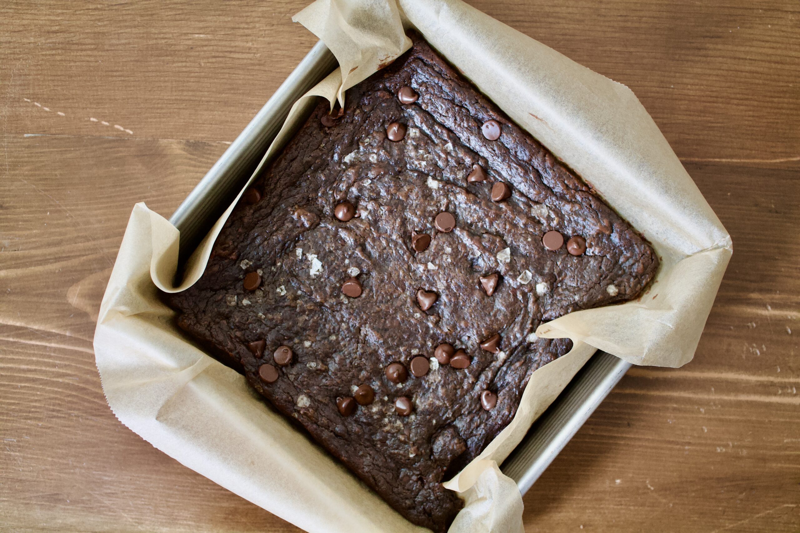 chocolate brownies in a parchment lined baking square